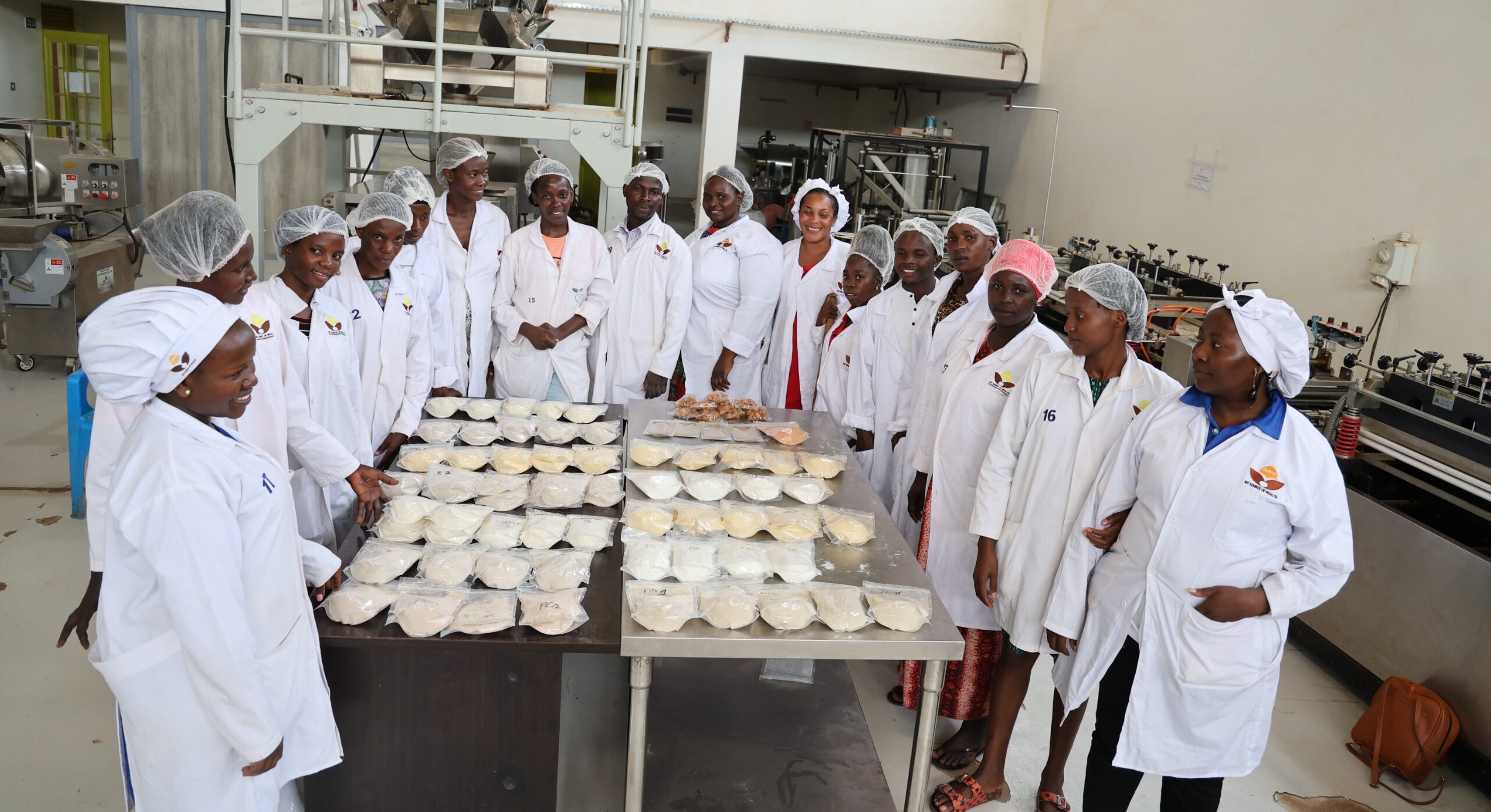 Cooks in a bakery supported by CURAD stood around some tables of food